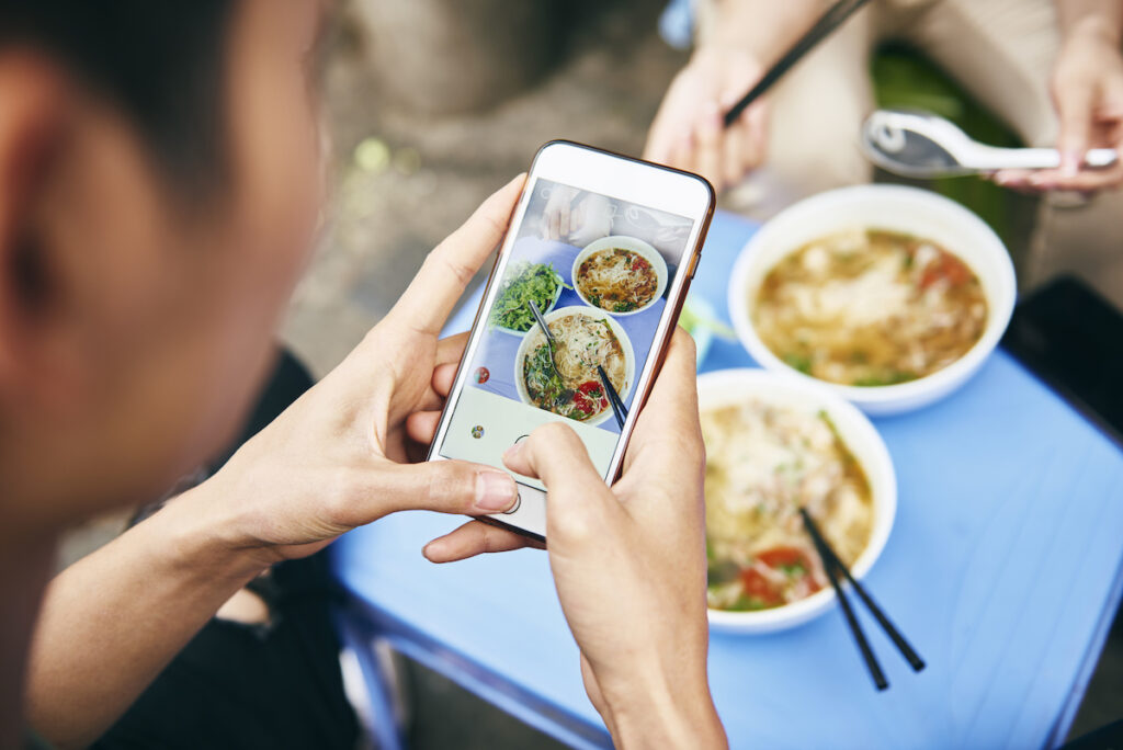 Persona sacando una foto a la comida callejera en Hanoi, capital de Vietnam