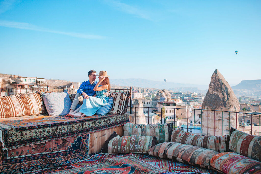 Pareja en una terraza de Capadocia  con globos aerostáticos (Turquía)