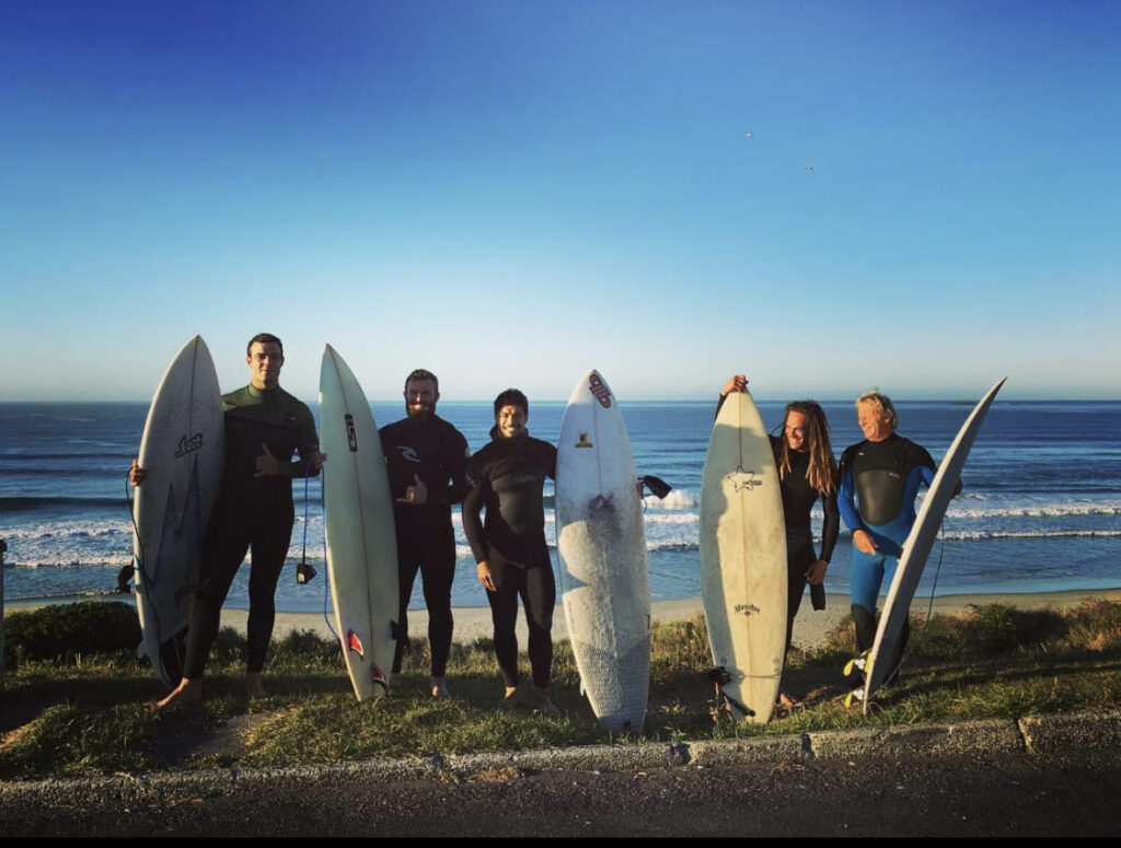 Dan Pryor, exjugador de los All Blacks con un grupo de amigos haciendo surf en la Isla Norte de Nueva Zelanda 