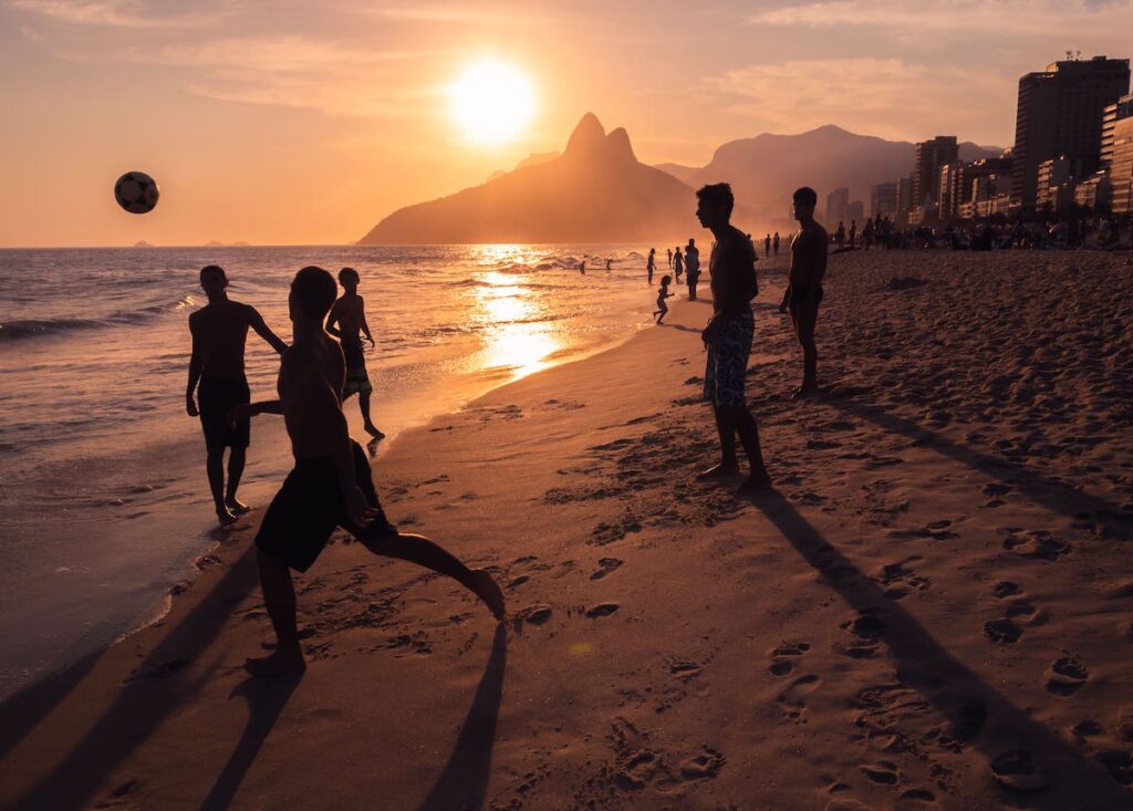 Grupo de jóvenes jugando al fútbol en la playa de Ipanema