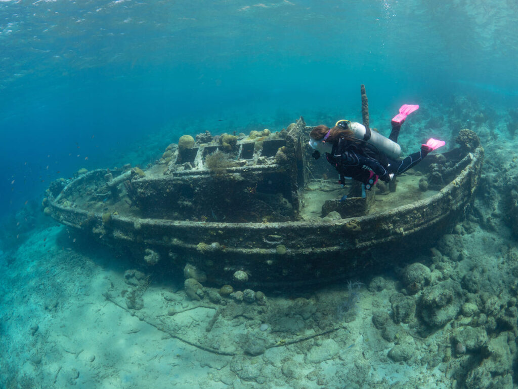 Mujer haciendo snorkel en el barco hundido "tugboat" en Curaçao 